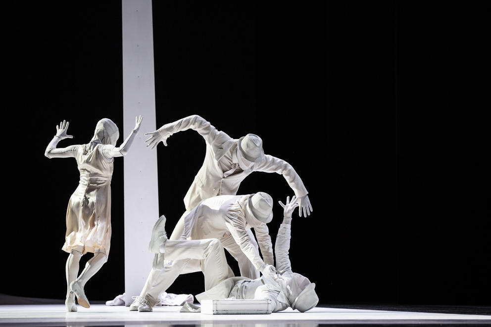 dancers dressed in all white and white masks on stage