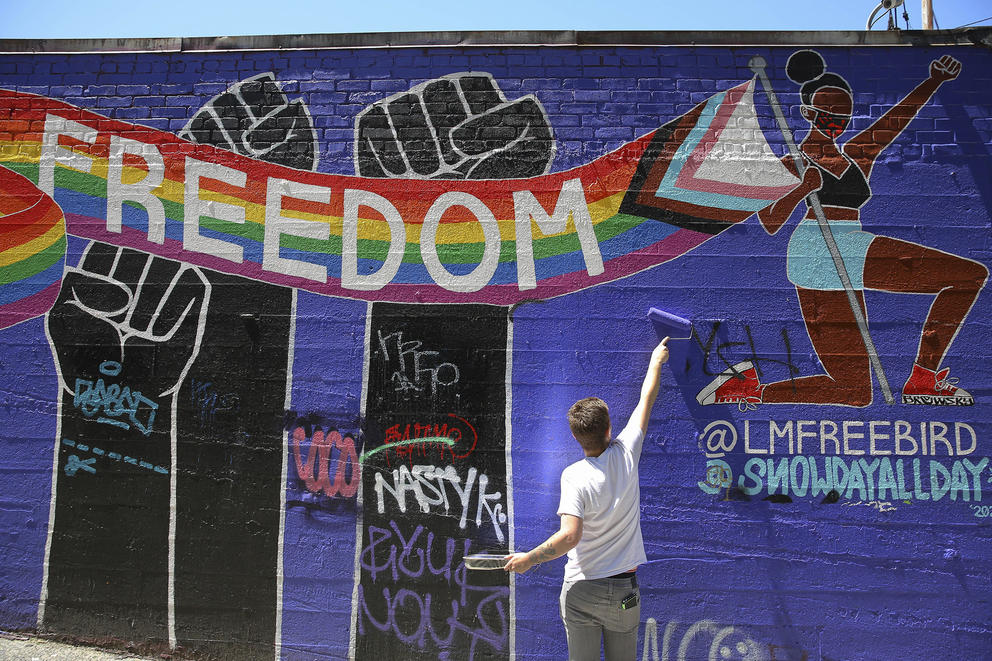 Colton Kenyon touches up a mural 