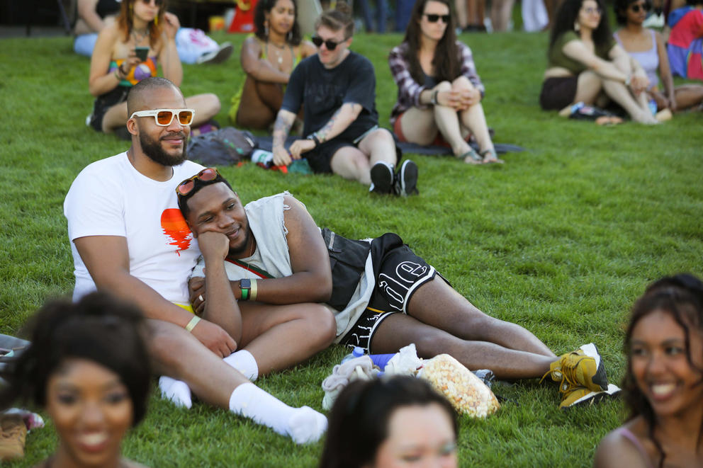 a crowd of people sit in the grass