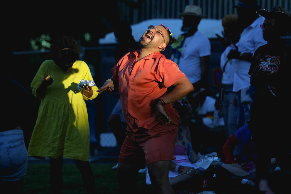 a person wearing orange dances in a spot of sunshine