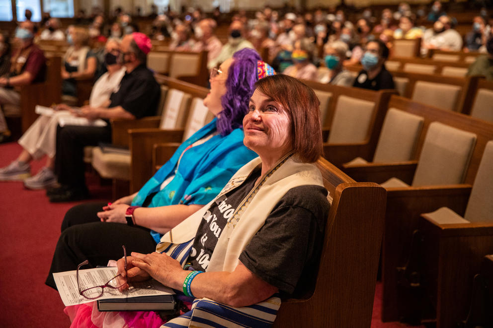 people sit in seats in a synagogue 