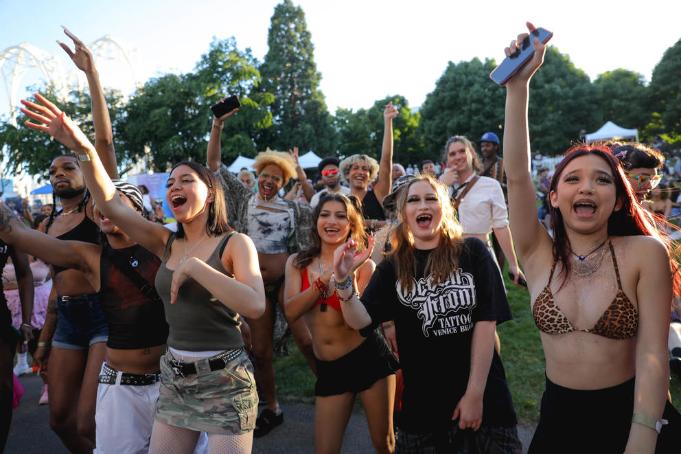 a crowd of people cheer and sing outside