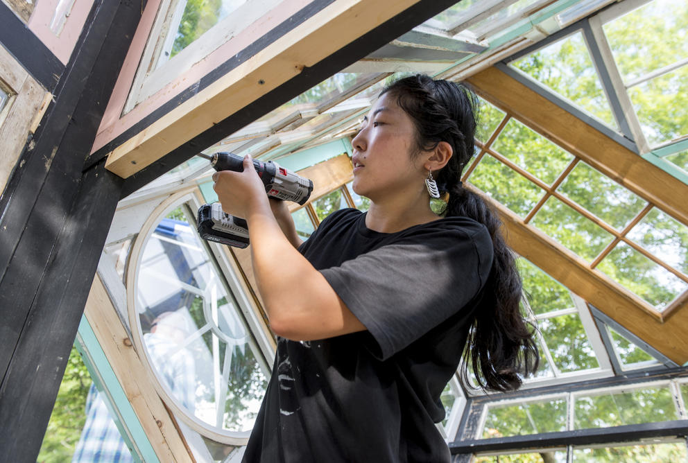 Amano with a power tool surrounded by glass windows