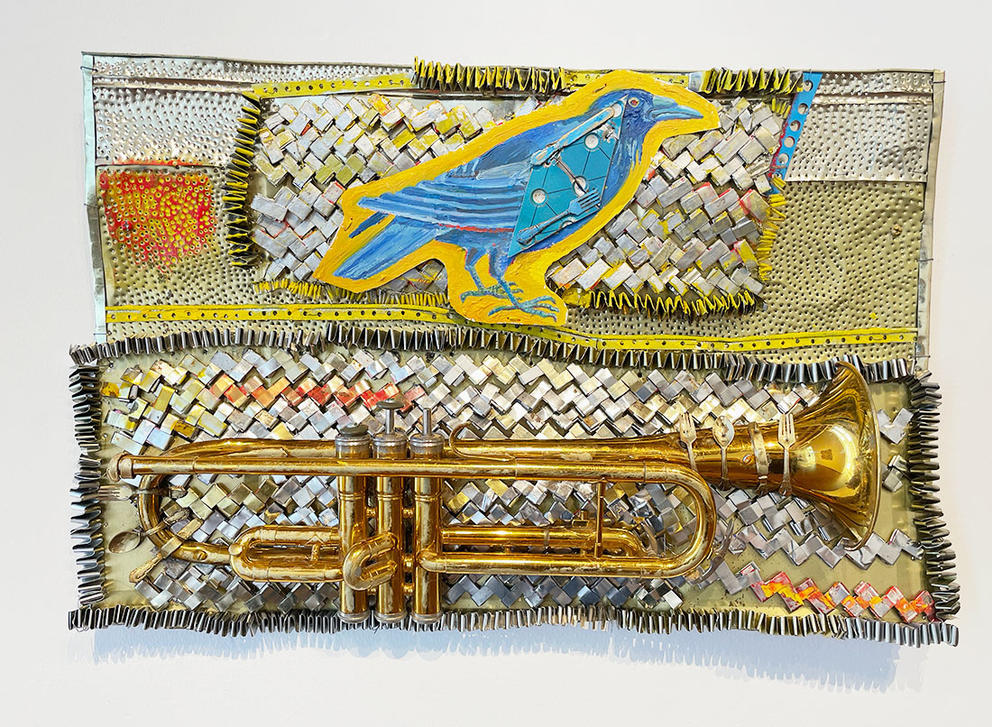 a hanging metal quilt with a trumpet and a blue bird on it