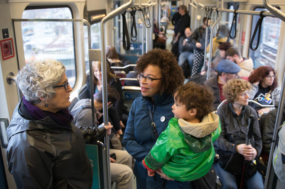 Kirsten Harris-Talley holds her child while talking on a train