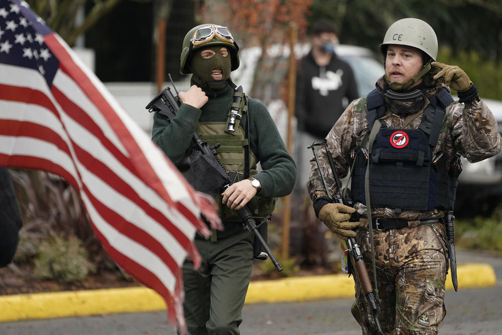 Flag and two people with guns and helmets