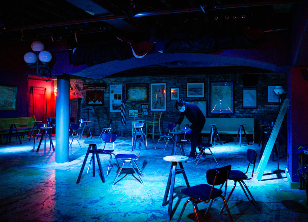 A worker sets up tables and chairs