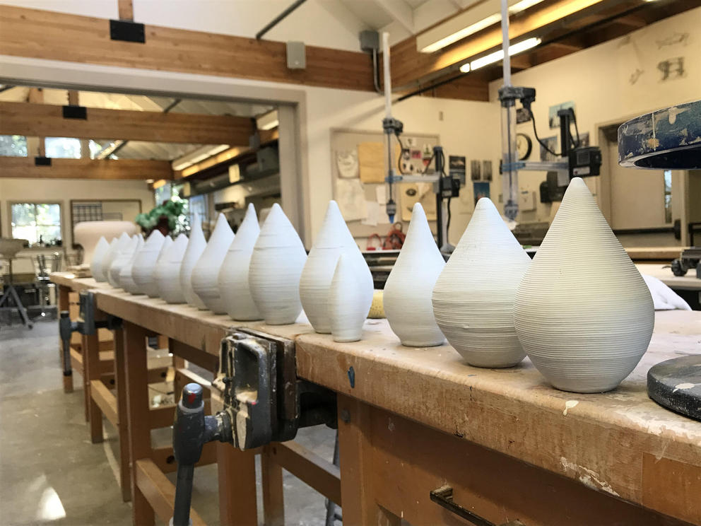 an artist studio with a shelf of ceramic raindrops 