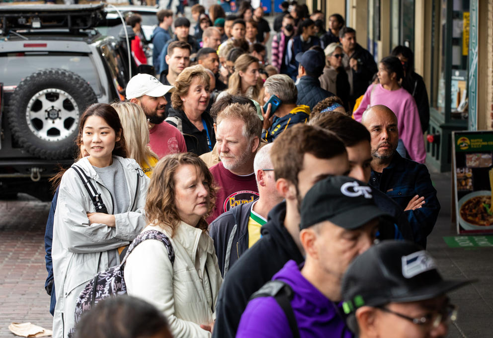 A line of people stand outdoors