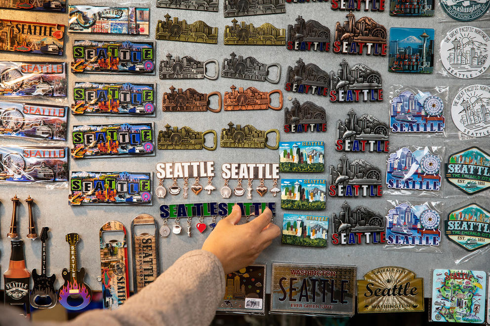 A hand reaches for a souvenir Seattle magnet