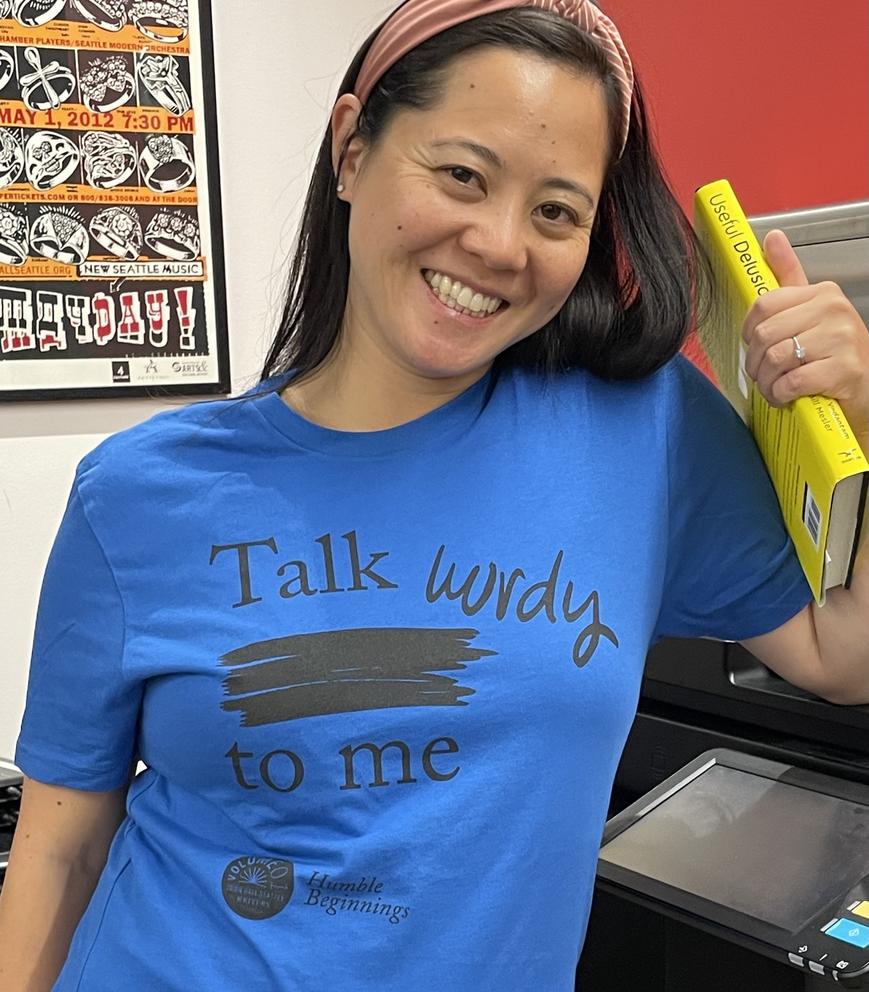 a woman in a blue t-shirt that reads "talk wordy to me"