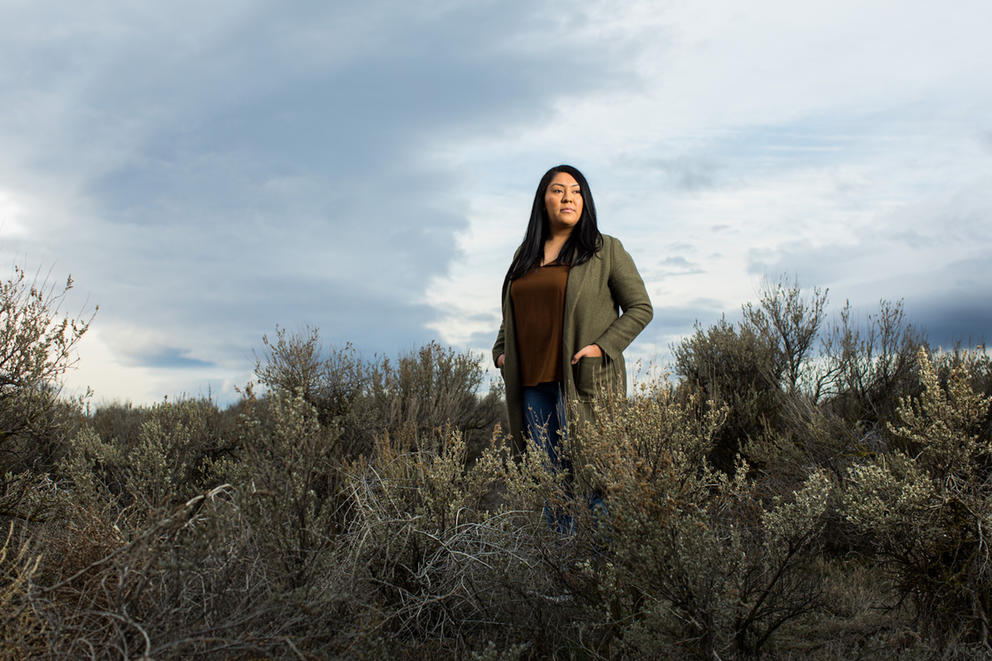 A woman stands in a patch of shrubs