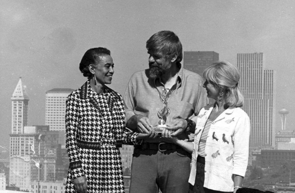 vintage outdoor photo of a black woman, a white bearded man, and a short blond woman