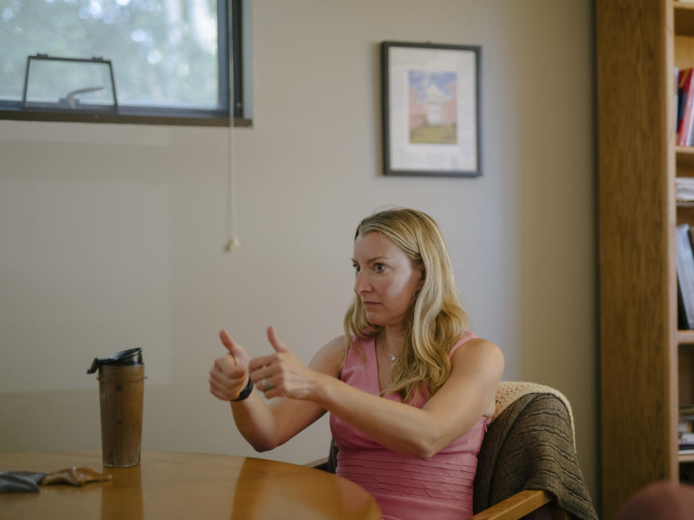 Woman seated at desk gives two thumbs up