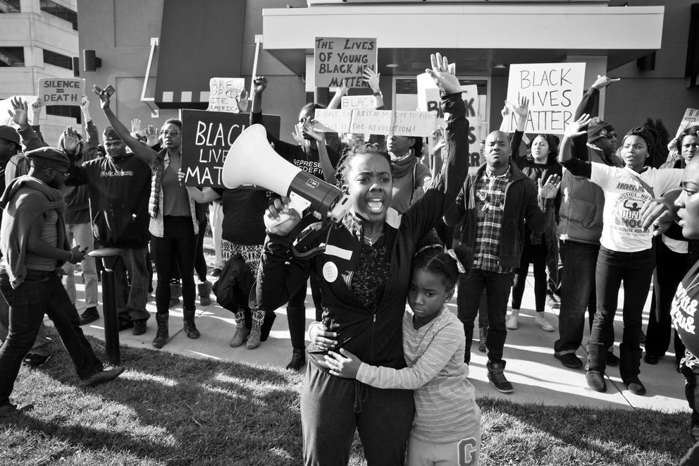 a black and white photo of a protester amid a group of protesters