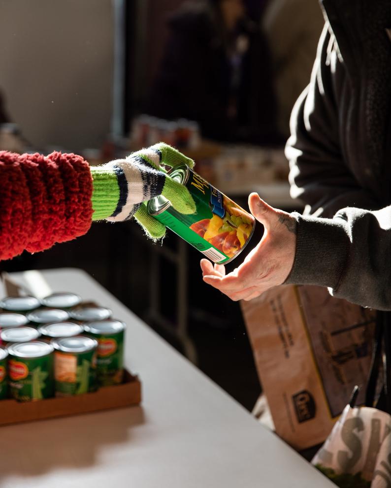 volunteers pass out canned foods