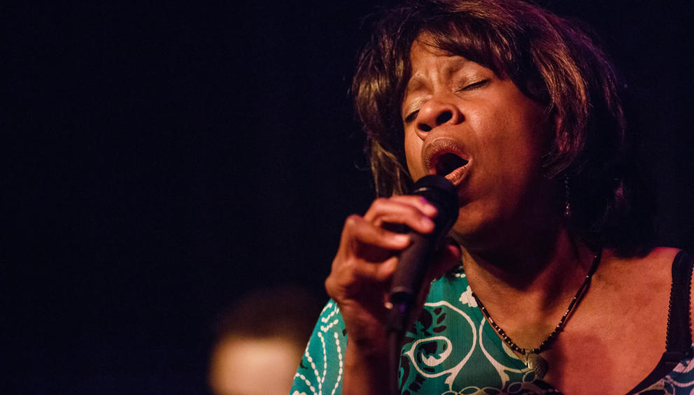 photo of a woman singing into a microphone