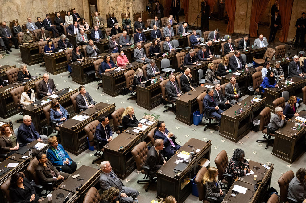 A picture of Washington legislators listening to Gov. Jay Inslee speak.