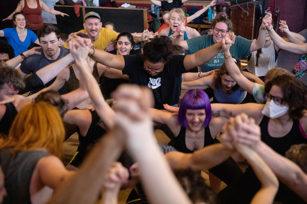 close up of a crowd of people dancing with hands raised and clasped