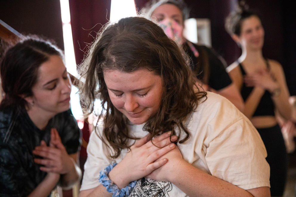 people in a dance class hold their hands to their hearts