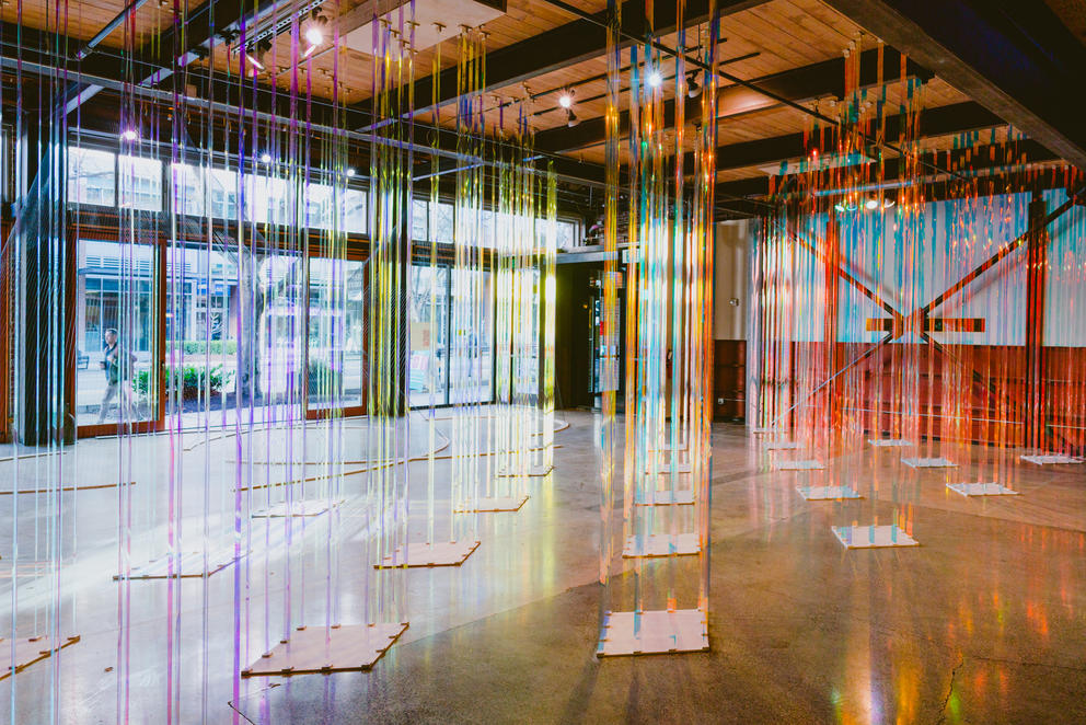 photo of a big empty street front gallery with iridescent strips hanging throughout