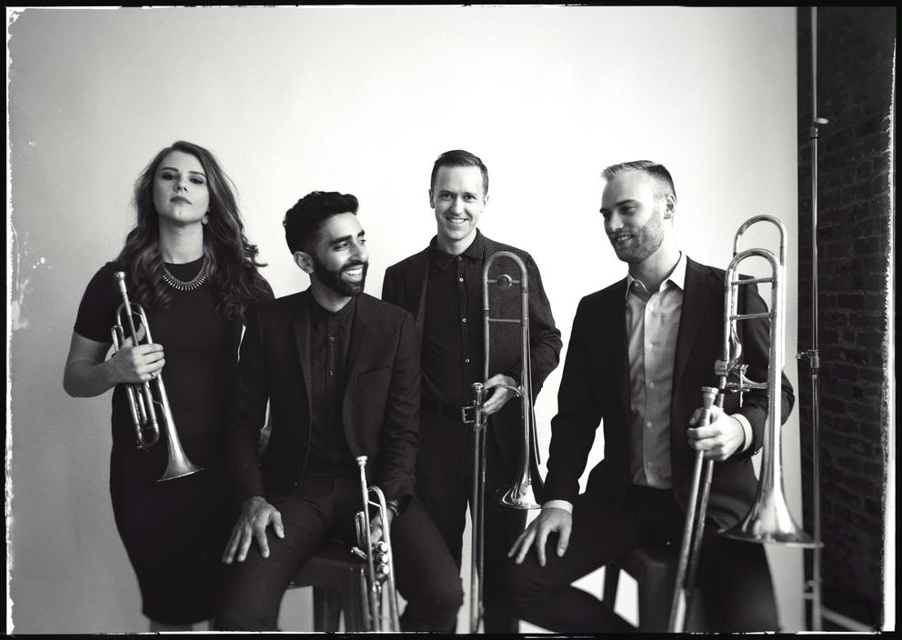 Black and white photo of four musicians holding brass instruments