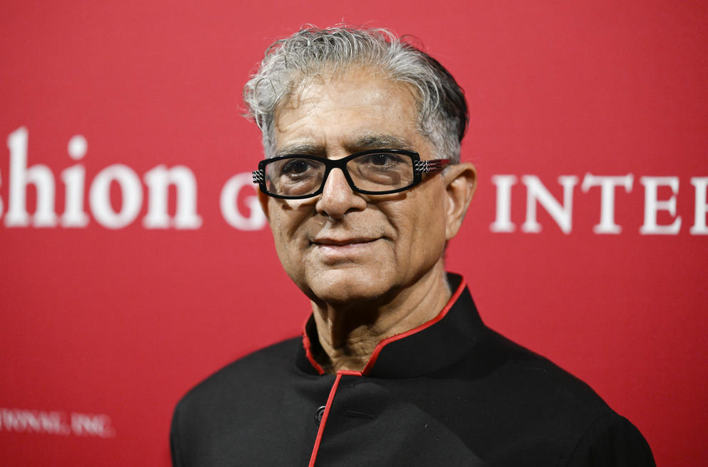 Portrait of a man with glasses and gray hair against a red backdrop