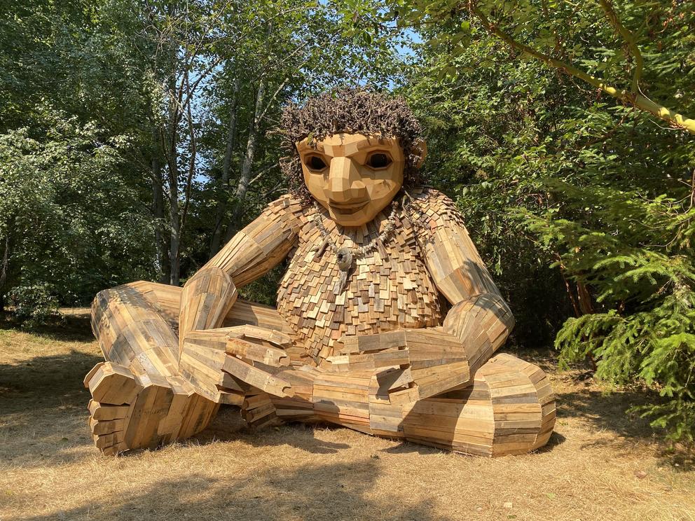 sculpture of a giant, seated troll, made of individual wooden planks