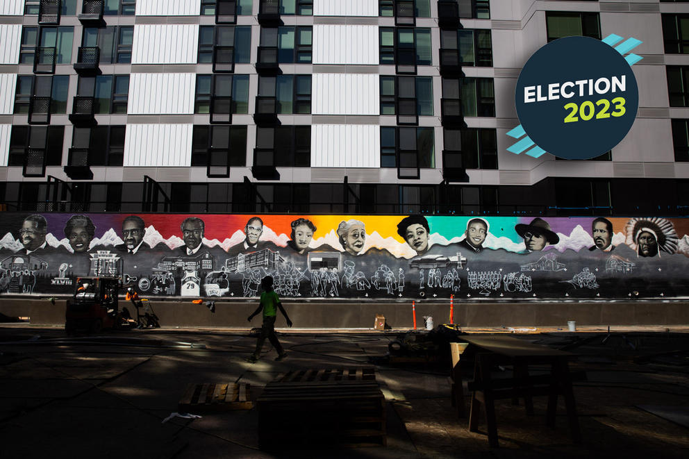 a colorful mural with many faces painted on the outside of an apartment building