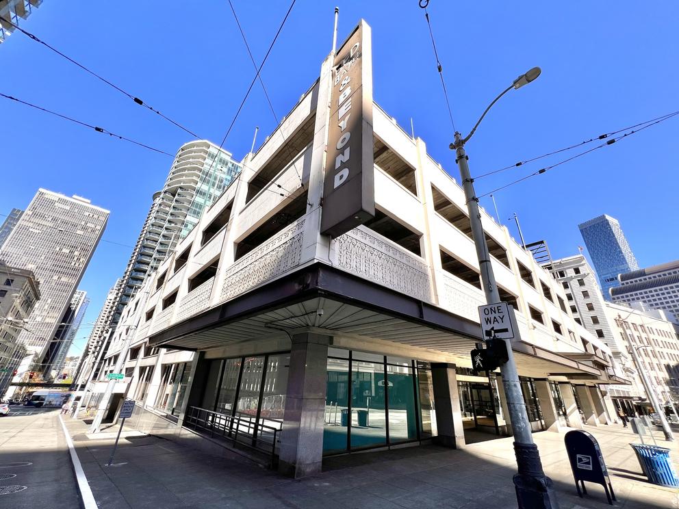 street view of a large white building with a parking garage on top