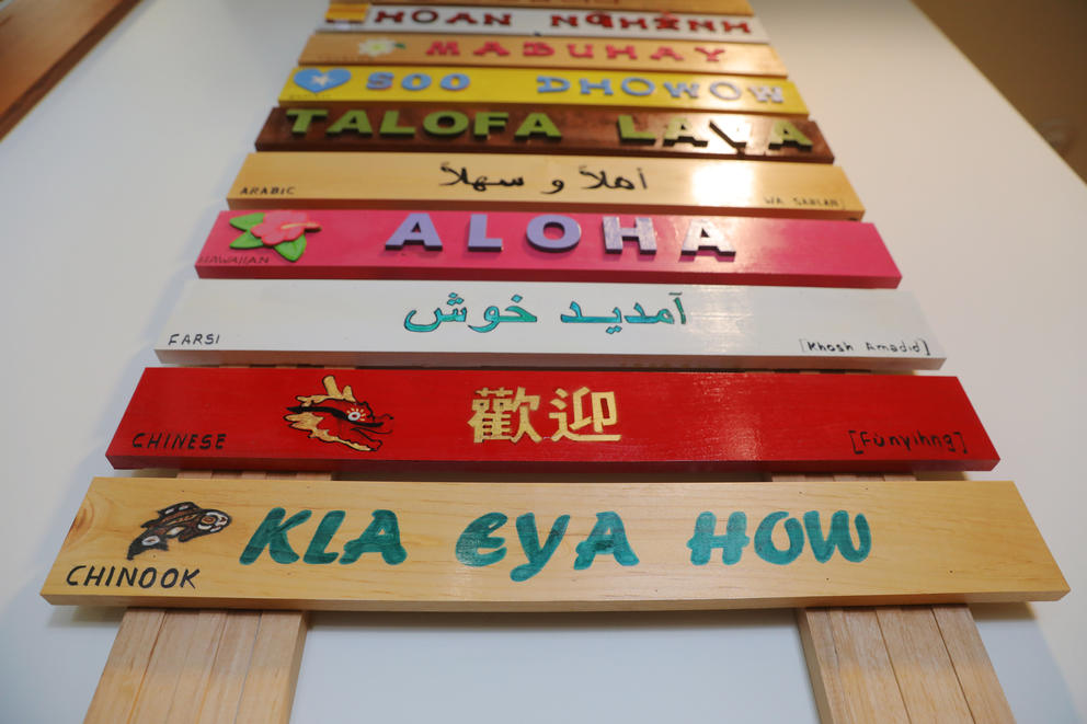 A sign at Parkside Elementary lists greetings in many languages including Chinook, Chinese, Farsi, Hawaiian and Arabic. The school encourages students to speak their home language in school just as much as they tell them to speak in English. (Genna Martin/Cascasde PBS)