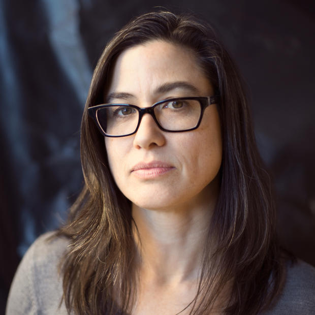 woman in glasses looking at the camera