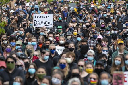 Protesters with sign reading “Listen to Black voices”