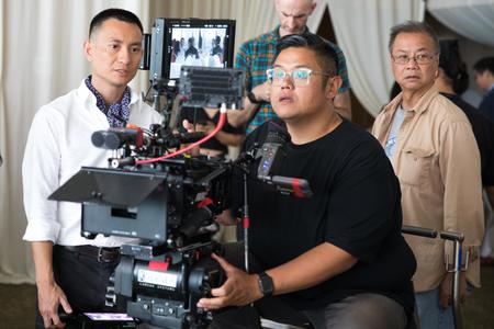 Men gather around a movie camera