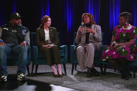 Four people sitting on a stage