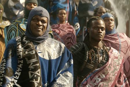 a movie still from Wakanda Forever, featuring warriors dressed in battle gear and ornate blankets