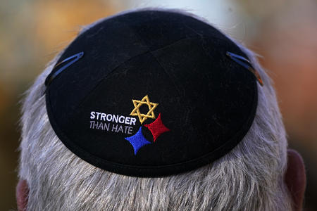 A yarmulke on a man’s head, featuring a Star of David and the words ‘stronger than hate’