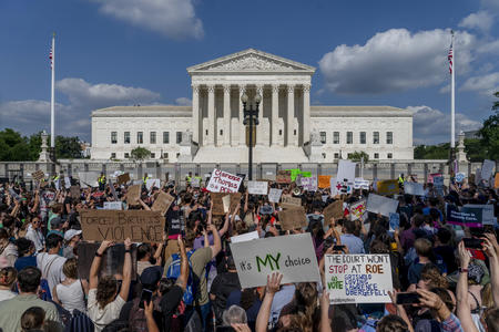 Demonstrators with signs in front of a neoclassical building