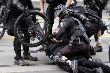 Police use a bike to subdue a person