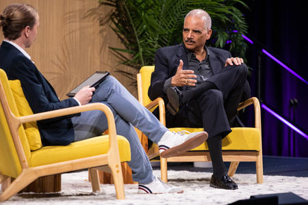 Two men sitting on stage, talking