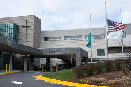 A picture of a hospital building with a cross on the outside of the building and a sign that says "St. Francis Hospital West Entrance"