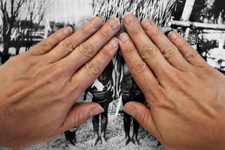 A person's hands cover a black-and-white image